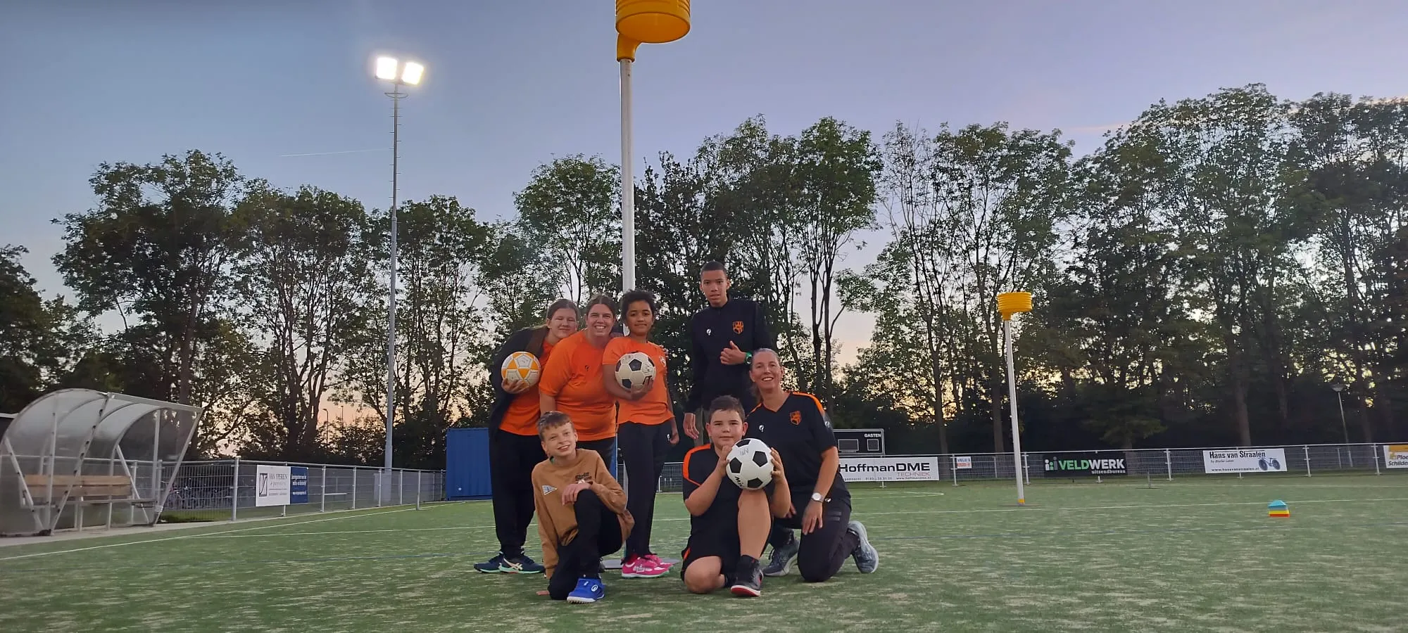 De Kanjers met hun trainers op het veld bij Merenveld